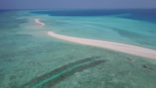 Luftaufnahmen der perfekten Strandzeit an der Küste durch blaues Wasser mit weißem Sandgrund — Stockvideo