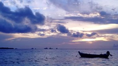 Şeffaf deniz kenarında, beyaz kumlu arka planda tropikal deniz kıyısı manzarası.