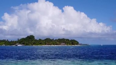 Lüks tatil beldesinin mavi deniz ve beyaz kum arka planındaki hava aracı dokusu.