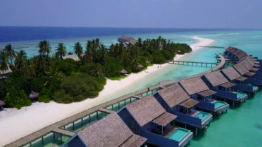 Mavi yeşil okyanus ve beyaz kum arka planının rahatlatıcı lagün plaj macerasının hava aracı doğası.