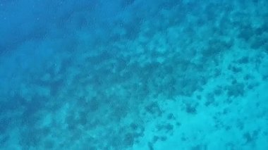 İnsansız hava aracı manzaralı egzotik sahil plajı turizmi beyaz kumlu arka planlı turkuaz denizi kırıyor.