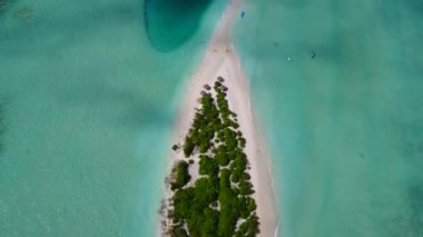 Şeffaf lagün ve beyaz kum arka planıyla cennet gibi turistik sahil yolculuğunun insansız hava aracı manzarası.