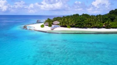 Beyaz kumlu arka planlı sığ deniz kıyısında rahatlatıcı sahil tatilinin insansız hava aracı yolculuğu