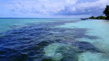 Egzotik körfez kumsalının gökyüzü parlak kumlu arka planda berrak bir göl tarafından yıkılıyor.