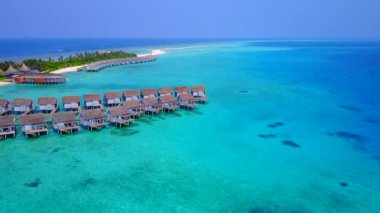 Mavi deniz kıyısında beyaz kumlu arka planda sakin deniz maceralarının insansız hava aracı.