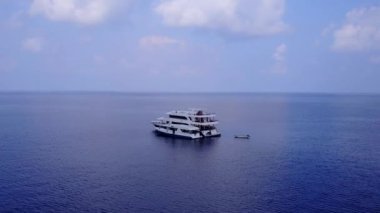Sakin deniz manzaralı, mavi deniz kenarında beyaz kumlu arka planda insansız hava yolculuğu.