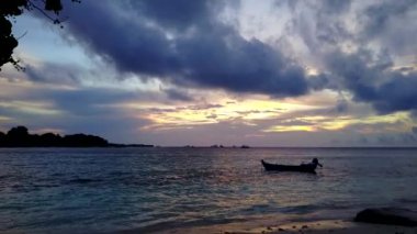 Şeffaf su ve parlak kumlu arka planda dinlendirici tatil beldesi manzarası