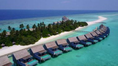 Deniz kıyılarının insansız hava aracı sahili turkuaz okyanus ve beyaz kum arka planıyla yıkılıyor.