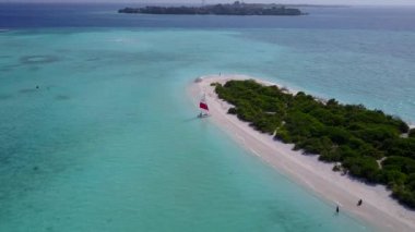 Şeffaf lagün ve beyaz kumlu arka planda sakin bir sahil gezisinin insansız hava aracı doğası