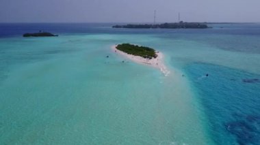 Mavi yeşil deniz ve beyaz kum arka planındaki sakin lagün sahil yolculuğunun insansız hava aracı.