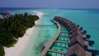 Mavi gölün kıyısında, beyaz kumlu arka planı olan sakin sahil saatinin hava aracı.