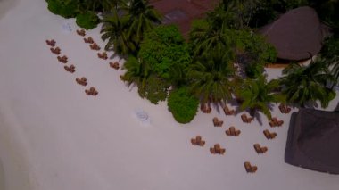 Tropikal körfez sahil saatinin İHA görüntüsü beyaz kum arka planlı mavi lagün tarafından