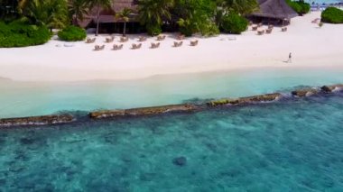 Mavi deniz kıyısında beyaz kumlu arka planda mükemmel bir turistik tatil manzarası.