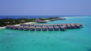 Beyaz kumlu arka planlı, berrak okyanusun kıyısındaki turistik plaj tatilinin insansız hava aracı deniz manzarası