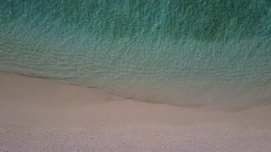 Mavi deniz ve beyaz kum arka planındaki lüks sahil gezisi için hava aracı manzarası.