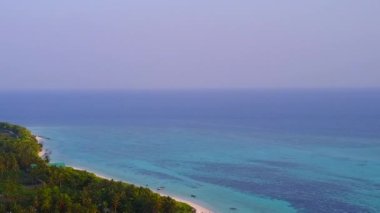 Mükemmel körfez kumsalının gökyüzü mavi okyanus ve parlak kum arka planıyla kırılıyor.