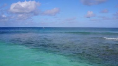 Beyaz kumlu arka planlı mavi yeşil okyanus tarafından tropikal sahil saatinin hava turizmi