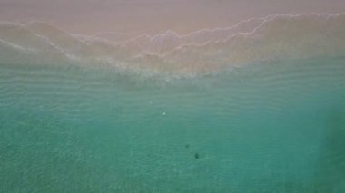 Güzel sahil şeridinin insansız hava yolculuğu mavi su ve beyaz kum arka planıyla kesiliyor.