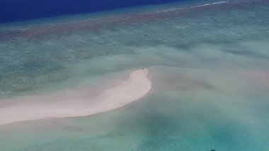 Berrak deniz ve temiz kumlu zemin ile cennet gibi bir sahil yolculuğunun insansız hava aracı dokusu