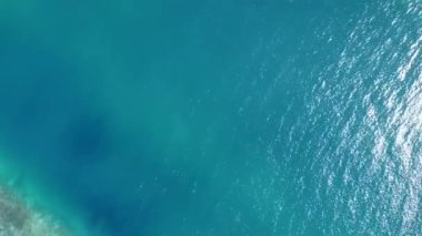 Mavi deniz ve parlak kum arkaplanı boyunca uzanan cennet gibi göl sahillerinin insansız hava aracı manzarası.