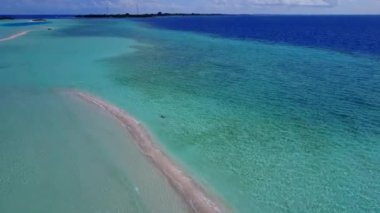 Mavi lagün ve beyaz kum arka planıyla lüks sahil seyahatinin havadan doğası.