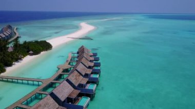 Şeffaf deniz ve beyaz kumlu arka planda sakin sahil tatillerinden oluşan hava aracı panoraması