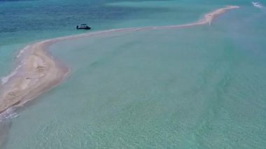 Beyaz kum arka planlı mavi deniz kıyısında rahatlatıcı deniz maceralarının insansız hava aracı yolculuğu.
