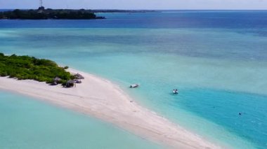 Beyaz kum arka planlı mavi lagünün yanındaki tropikal sahil gezisinin hava manzarası.