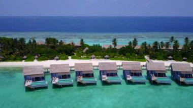 Mavi deniz ve beyaz kumlu arka planda deniz kıyısı tatilinin insansız hava aracı yolculuğu