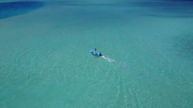 Beyaz kumlu arka planlı sığ deniz kıyısında cennet sahili tatili.