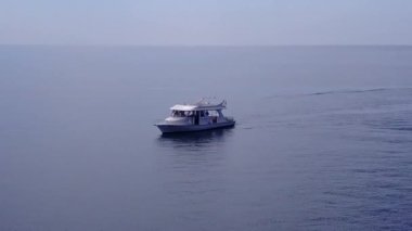 Deniz kıyılarının insansız hava aracı sahili temiz kum arka planıyla şeffaf okyanus tarafından yıkılıyor.