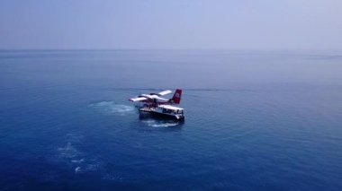 Şeffaf lagünün beyaz kum arka planında sakin sahil yolculuğunun insansız hava aracı deniz manzarası.