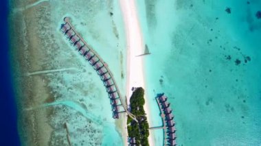 Cennet kıyı şeridinin hava aracı manzarası. Beyaz kumlu arka planda mavi yeşil bir lagün.