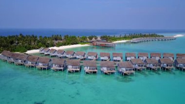 Beyaz kumlu arka planlı mavi lagün ile lüks deniz kıyısı seyahatinin insansız hava aracı.
