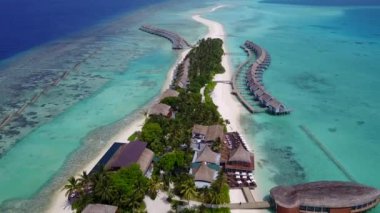 Mavi okyanusun beyaz kumlu arka planında tropikal sahil maceralarının hava aracı panoraması