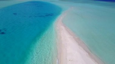 Mavi göl kıyısında, parlak kumlu arka planda, cennet gibi bir sahil gezisinin insansız hava aracı manzarası