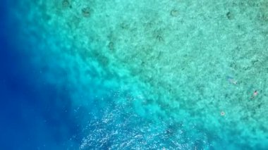 Egzotik deniz manzaralı kumsalın hava aracı dokusu mavi deniz ve beyaz kum arka planıyla kırılıyor.