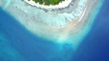 Beyaz kumlu arka planlı mavi deniz kıyısında deniz turistlerinin hava aracı panoraması.