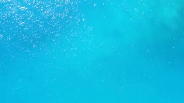 Mavi lagün ve beyaz kum arka planındaki deniz turistlerinin hava aracı manzarası.