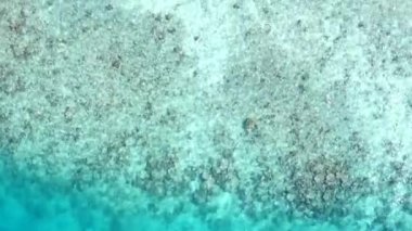 Mavi su ve beyaz kum arka planında egzotik deniz manzaralı sahil saatinin insansız hava aracı yolculuğu
