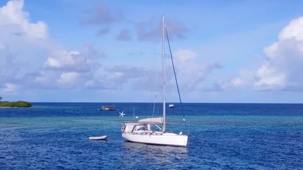 Luchtfoto van tropische kust strand vakantie door blauwe lagune en wit zand achtergrond — Stockvideo