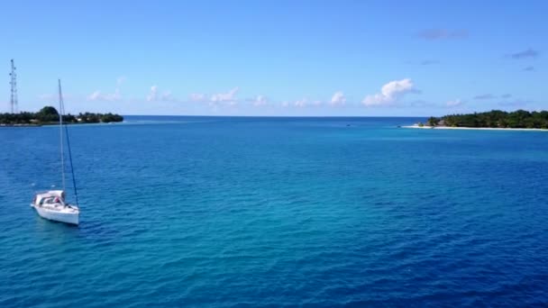 Turkuaz su ve beyaz kum arka planıyla sakin turistik sahil saatinin insansız hava yolculuğu. — Stok video