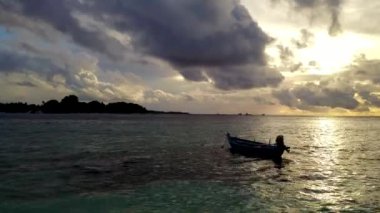 Mavi gölün kenarında beyaz kumlu arka planda sakin bir adanın hava aracı manzarası.