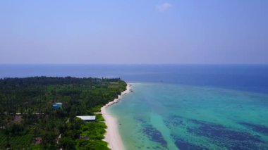 Beyaz kum arka planlı mavi deniz kıyısında egzotik sahil yolculuğunun insansız hava aracı yolculuğu.