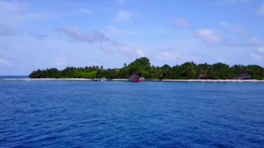 Berrak su ve beyaz kum arka planıyla cennet gibi bir sahil manzarası.