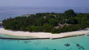Cennet kıyı şeridinin hava aracı manzarası. Mavi okyanus kıyısında, beyaz kum arka planda.