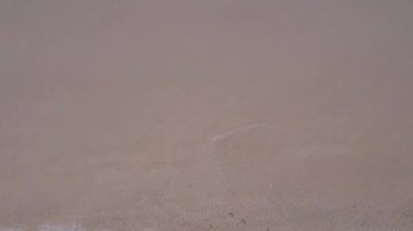 Cennet sahili sahil tatilinde temiz su ve parlak kumlu arka planla yapılan hava aracı yolculuğu.