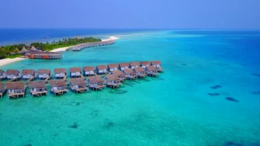 Cennetin gökyüzü kıyı sahili mavi yeşil lagün ve beyaz kumlu arka planda kırılıyor.