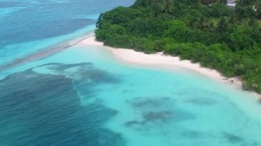 Mavi deniz ve beyaz kumlu arka planda sakin sahil yolculuğunun havadan görünüşü