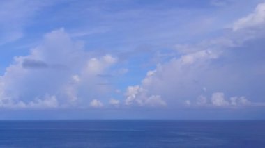 Beyaz kum arka planlı, berrak okyanus kıyısından tropik ada sahili manzarası.